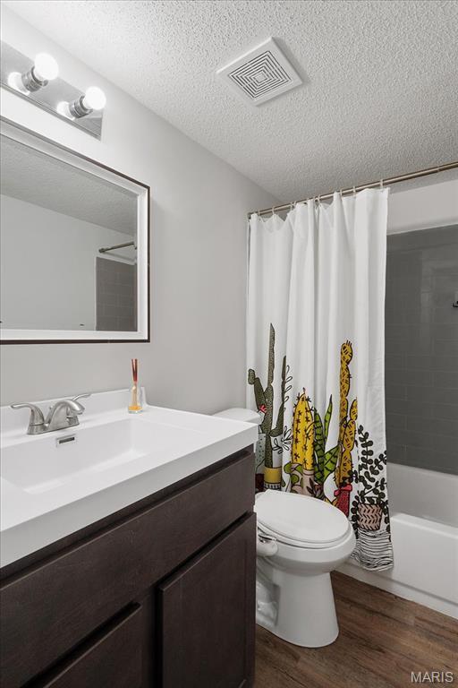 2014 Greenglen Dr Unit 101, Saint Louis, MO 63122 - full bath with wood finished floors, vanity, toilet, a textured ceiling, and shower / bath combo