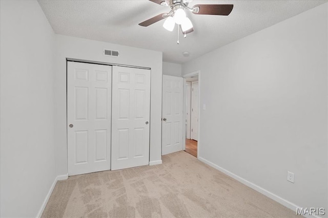 2014 Greenglen Dr Unit 101, Saint Louis, MO 63122 - unfurnished bedroom with light colored carpet, baseboards, a closet, a textured ceiling, and a ceiling fan