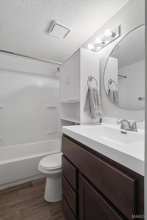 2014 Greenglen Dr Unit 101, Saint Louis, MO 63122 - bathroom with a textured ceiling, wood finished floors, toilet, vanity, and shower / washtub combination
