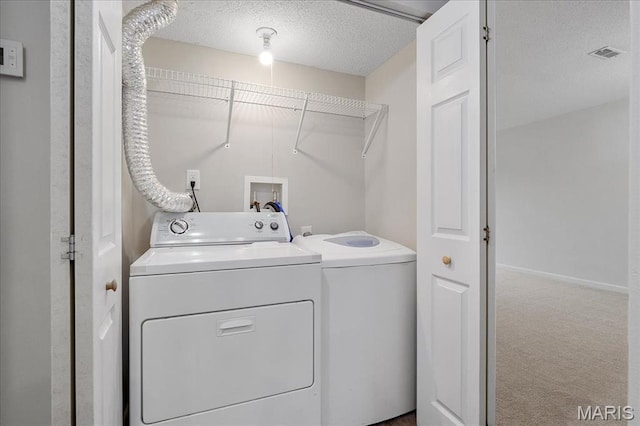 2014 Greenglen Dr Unit 101, Saint Louis, MO 63122 - laundry area with washer and dryer, a textured ceiling, carpet flooring, and baseboards