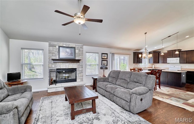 440 Winchester Way, Winfield, MO 63389 - living room with vaulted ceiling, a chandelier, ceiling fan, a stone fireplace, and dark wood-style floors