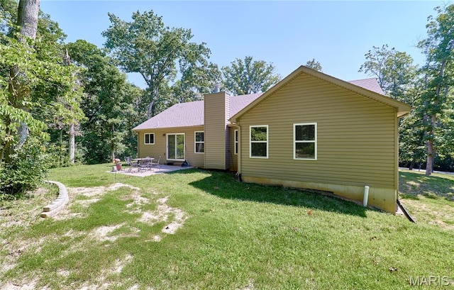 440 Winchester Way, Winfield, MO 63389 - back of property featuring a chimney, a patio area, and a lawn