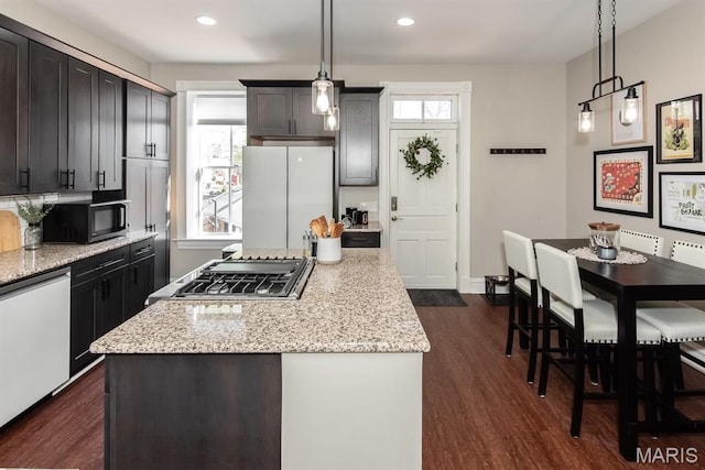 2712 Potomac St, Saint Louis, MO 63118 - kitchen with white appliances, a kitchen island, dark wood finished floors, light stone counters, and recessed lighting