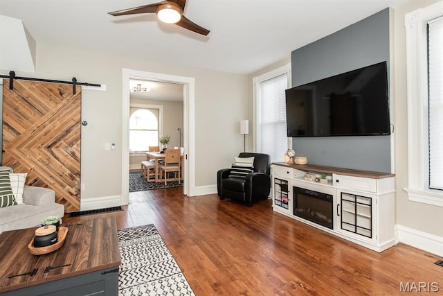 2712 Potomac St, Saint Louis, MO 63118 - living area with a ceiling fan, wood finished floors, a barn door, and baseboards