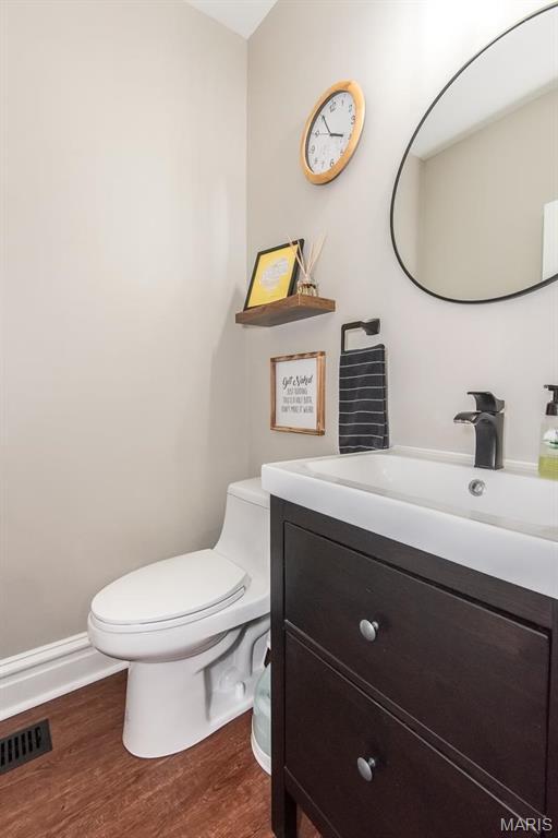2712 Potomac St, Saint Louis, MO 63118 - bathroom featuring vanity, toilet, and wood finished floors