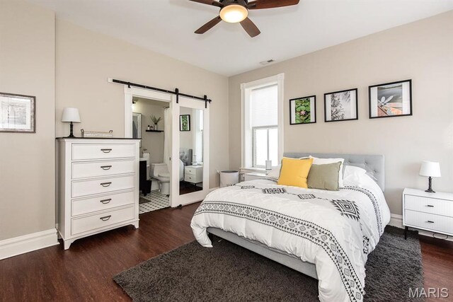 2712 Potomac St, Saint Louis, MO 63118 - bedroom with a barn door, dark wood-style floors, baseboards, and ensuite bathroom