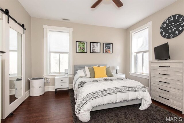 2712 Potomac St, Saint Louis, MO 63118 - bedroom featuring a barn door, dark wood finished floors, baseboards, and a ceiling fan