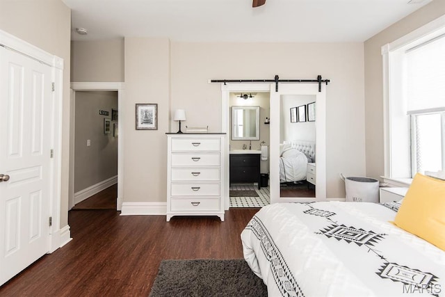 2712 Potomac St, Saint Louis, MO 63118 - bedroom featuring dark wood-style floors, a barn door, baseboards, a sink, and connected bathroom