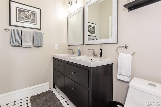 2712 Potomac St, Saint Louis, MO 63118 - bathroom with tile patterned floors, double vanity, toilet, and baseboards