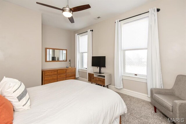 2712 Potomac St, Saint Louis, MO 63118 - carpeted bedroom with multiple windows, baseboards, and a ceiling fan