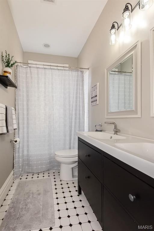 2712 Potomac St, Saint Louis, MO 63118 - bathroom featuring toilet, vanity, and tile patterned floors