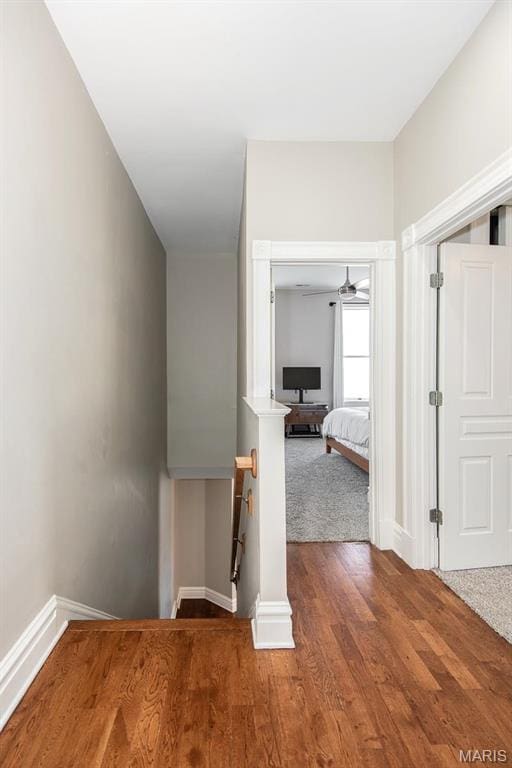 2712 Potomac St, Saint Louis, MO 63118 - hallway with baseboards, wood finished floors, and an upstairs landing