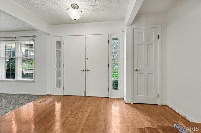 13355 Land O Woods Dr, Saint Louis, MO 63141 - entryway with a textured ceiling, healthy amount of natural light, wood finished floors, and baseboards