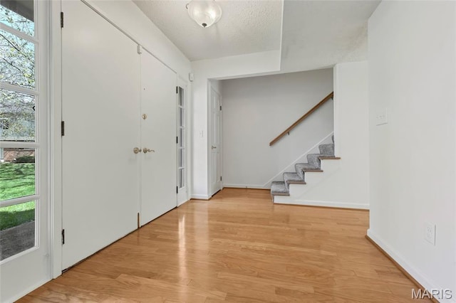 13355 Land O Woods Dr, Saint Louis, MO 63141 - foyer with stairs, light wood-style floors, a textured ceiling, and baseboards