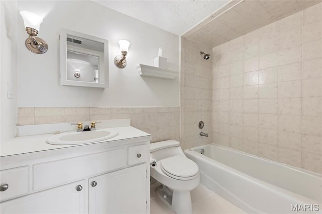 13355 Land O Woods Dr, Saint Louis, MO 63141 - full bathroom featuring tile walls, toilet, washtub / shower combination, tile patterned floors, and vanity