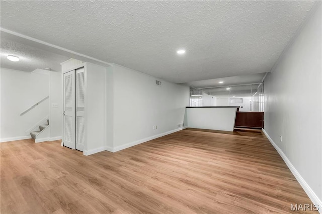 13355 Land O Woods Dr, Saint Louis, MO 63141 - finished below grade area with a textured ceiling, stairway, light wood-style flooring, baseboards, and recessed lighting