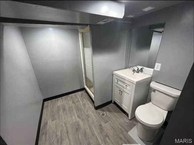 9647 Margo Ann Ln, Saint Louis, MO 63134 - bathroom featuring wood finished floors, toilet, vanity, baseboards, and a shower stall