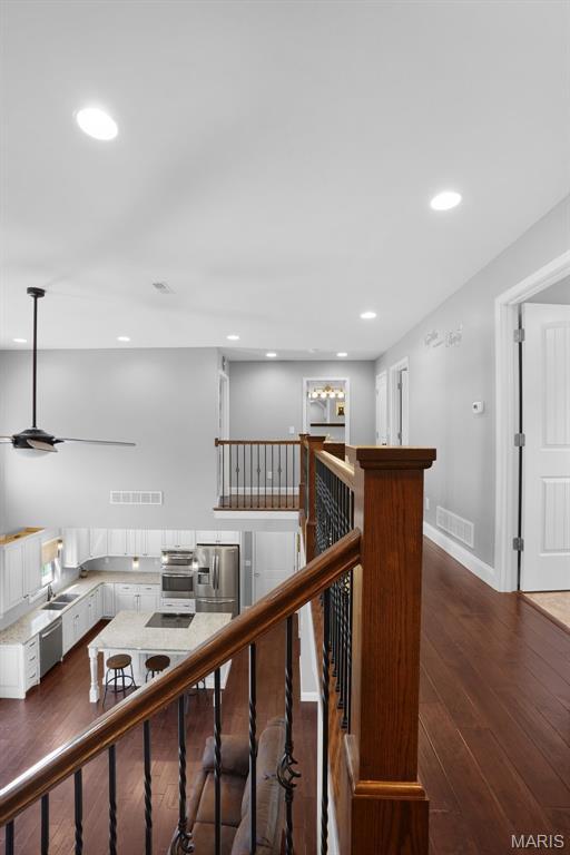 9336 Excelsior Rd, Gerald, MO 63037 - corridor featuring dark wood finished floors, recessed lighting, an upstairs landing, baseboards, and a sink