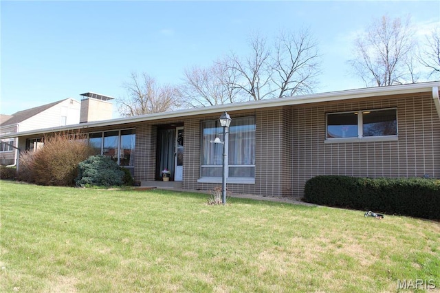 view of front of property featuring a front lawn and a chimney