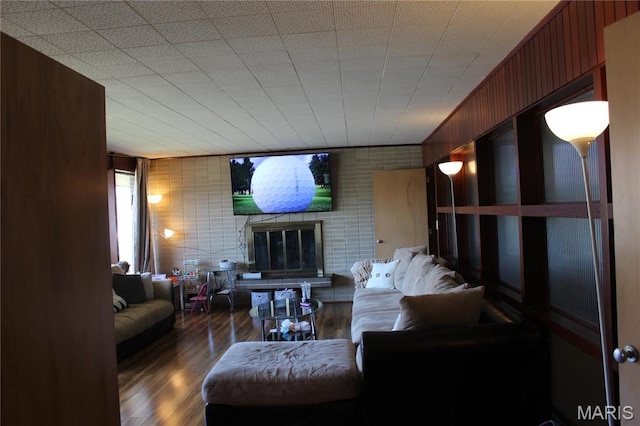 living room featuring a brick fireplace and wood finished floors