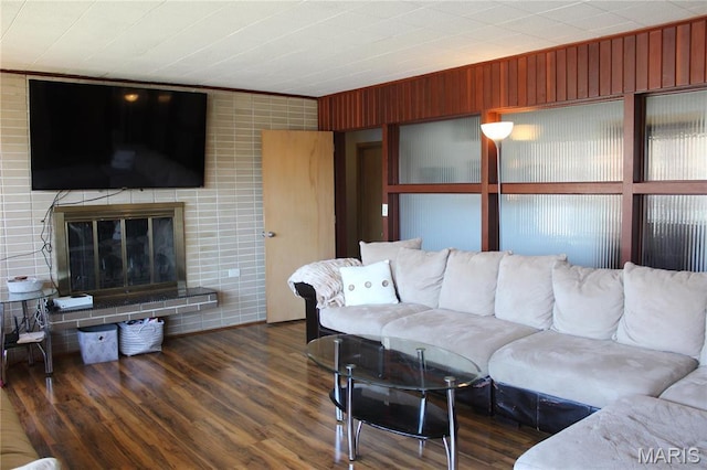 living area featuring wood finished floors and a glass covered fireplace