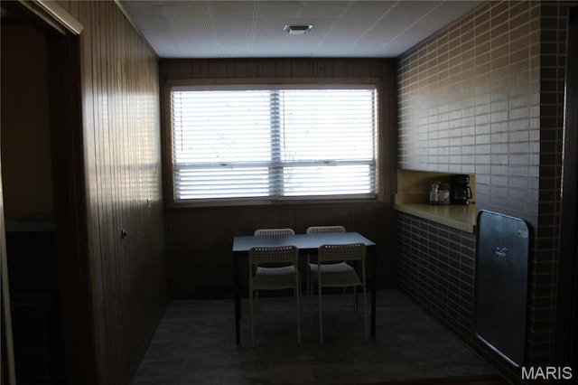dining room with wooden walls