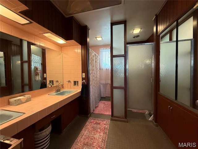 bathroom with a stall shower and double vanity
