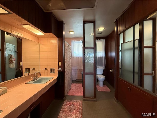 full bathroom with toilet, vanity, tile patterned flooring, a shower with shower curtain, and tile walls