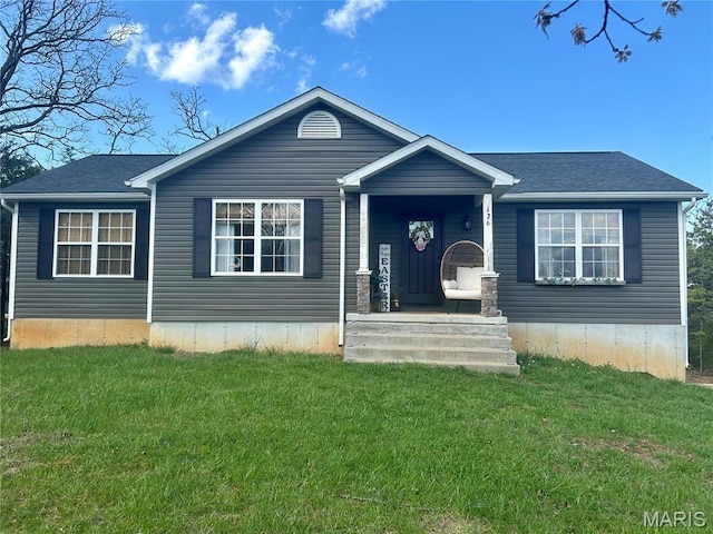 view of front facade with a front lawn and roof with shingles