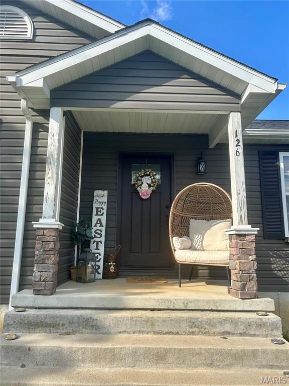 view of exterior entry featuring covered porch
