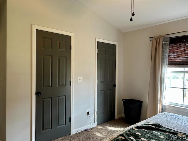 carpeted bedroom with baseboards and vaulted ceiling