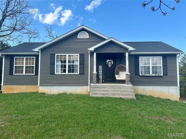view of front of home featuring a front lawn and a shingled roof