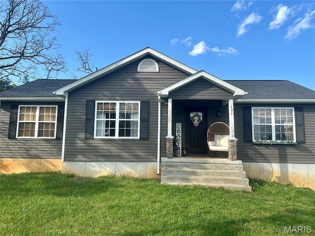 view of front facade featuring a front yard, a porch, and roof with shingles