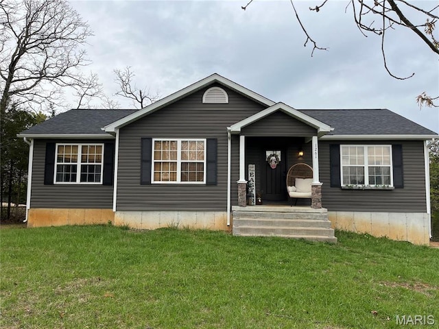 view of front of house with a front lawn, a shingled roof, and covered porch