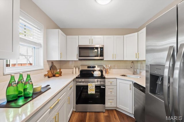 1551 Swallow Dr, Saint Louis, MO 63144 - kitchen featuring appliances with stainless steel finishes, a sink, light countertops, white cabinets, and tasteful backsplash