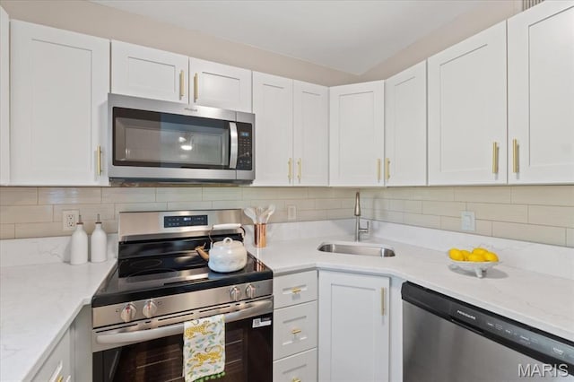 1551 Swallow Dr, Saint Louis, MO 63144 - kitchen featuring stainless steel appliances, a sink, white cabinetry, and backsplash