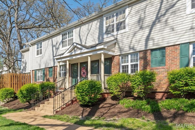 1551 Swallow Dr, Saint Louis, MO 63144 - view of front of home with brick siding, a porch, and fence