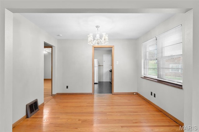 8900 Southview Ln, Saint Louis, MO 63123 - unfurnished dining area with a chandelier, light wood-style floors, and baseboards
