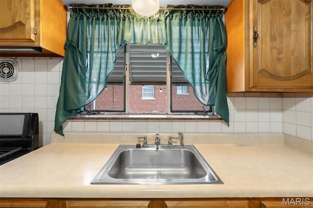 8900 Southview Ln, Saint Louis, MO 63123 - kitchen with a sink, light countertops, tasteful backsplash, and brown cabinetry