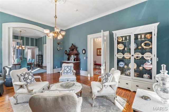 876 W State St W, Jacksonville, IL 62650 - living area with a chandelier, ornamental molding, wood finished floors, arched walkways, and baseboards