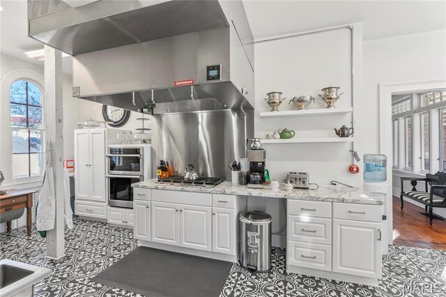 876 W State St W, Jacksonville, IL 62650 - kitchen featuring wall chimney exhaust hood, appliances with stainless steel finishes, white cabinets, and tile patterned flooring