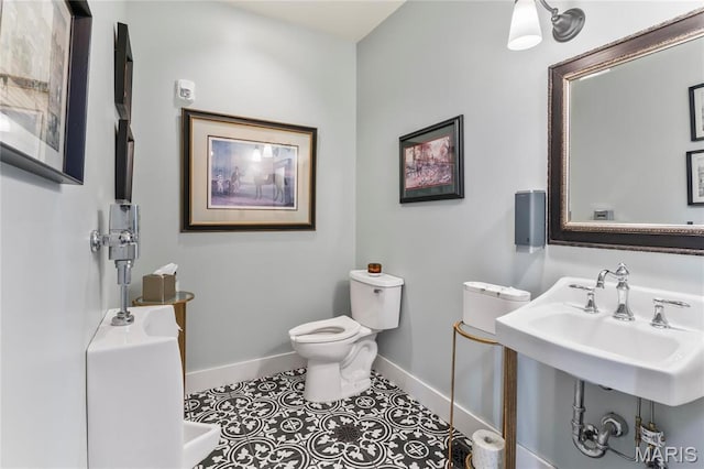 876 W State St W, Jacksonville, IL 62650 - bathroom with baseboards, toilet, and a sink