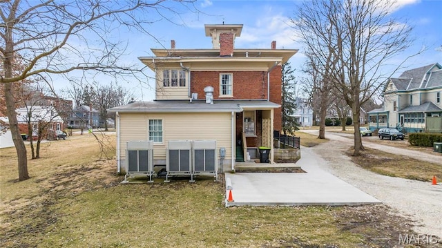 876 W State St W, Jacksonville, IL 62650 - back of house featuring a chimney, a yard, brick siding, and a residential view