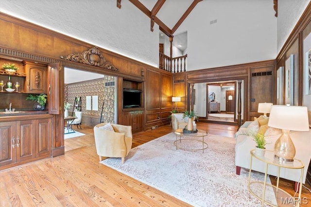 13596 Kings Glen Dr, Saint Louis, MO 63131 - living area featuring high vaulted ceiling, light wood-style floors, and wood walls