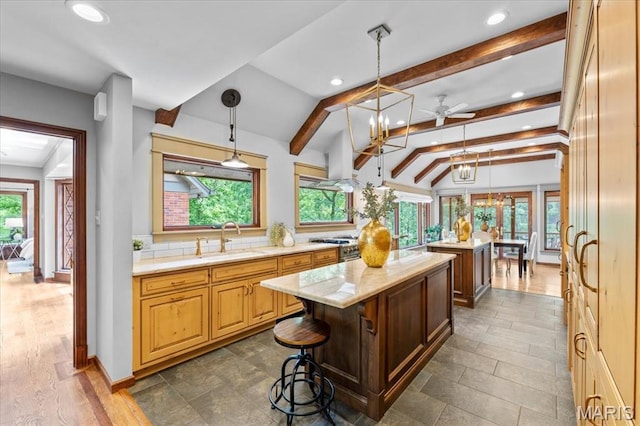 13596 Kings Glen Dr, Saint Louis, MO 63131 - kitchen featuring a sink, a center island, recessed lighting, beam ceiling, and decorative light fixtures