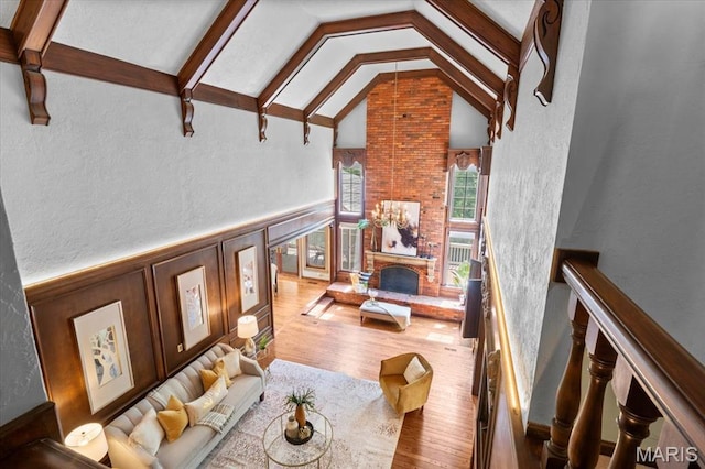 13596 Kings Glen Dr, Saint Louis, MO 63131 - living room with a textured wall, wood finished floors, high vaulted ceiling, a brick fireplace, and beamed ceiling