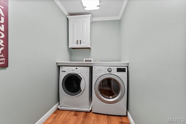13596 Kings Glen Dr, Saint Louis, MO 63131 - washroom featuring separate washer and dryer, crown molding, cabinet space, light wood-style flooring, and baseboards