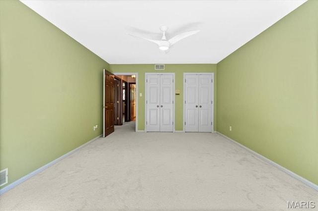 13596 Kings Glen Dr, Saint Louis, MO 63131 - unfurnished bedroom featuring two closets, light carpet, baseboards, and ceiling fan