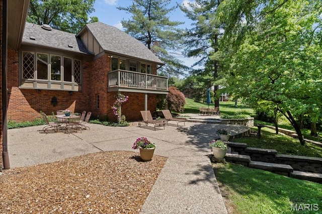 13596 Kings Glen Dr, Saint Louis, MO 63131 - view of side of home with brick siding, a patio area, a balcony, and a shingled roof