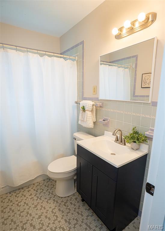 2917 Grand Ave, Granite City, IL 62040 - bathroom featuring vanity, tile walls, tile patterned floors, and a shower with shower curtain